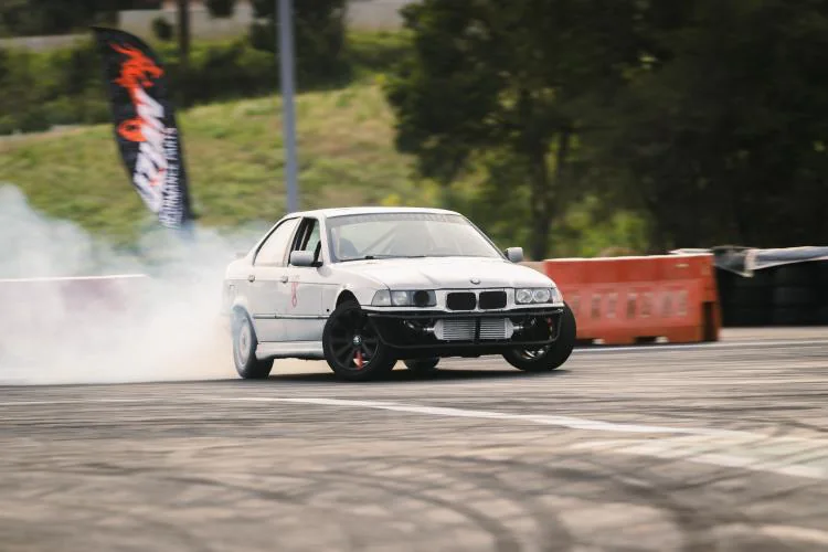 BMW E36 Açucarada fazendo drift na pista, ainda com a carroceria branca
