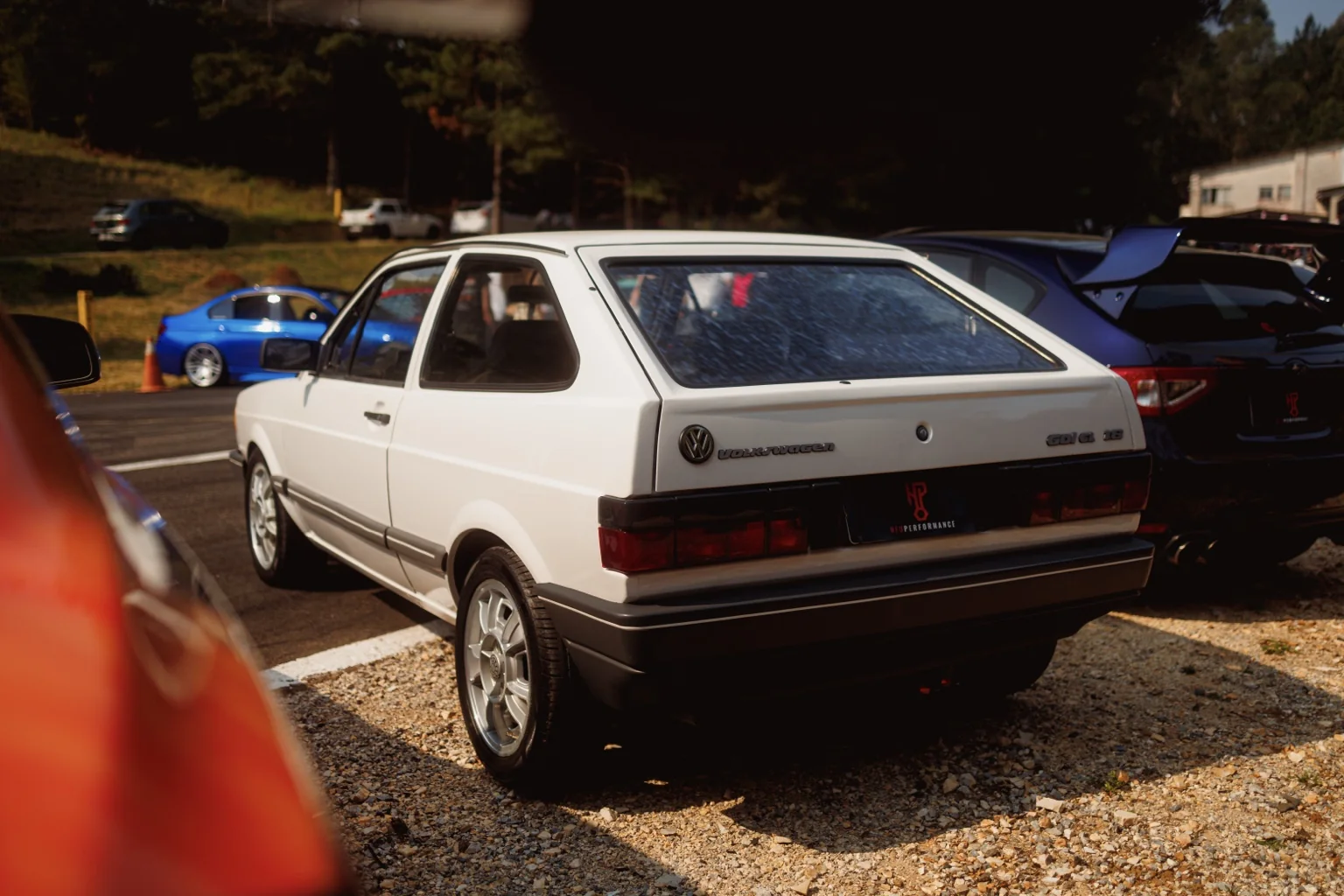 Gol Quadrado branco visto de trás em um encontro, com o WRX ao lado