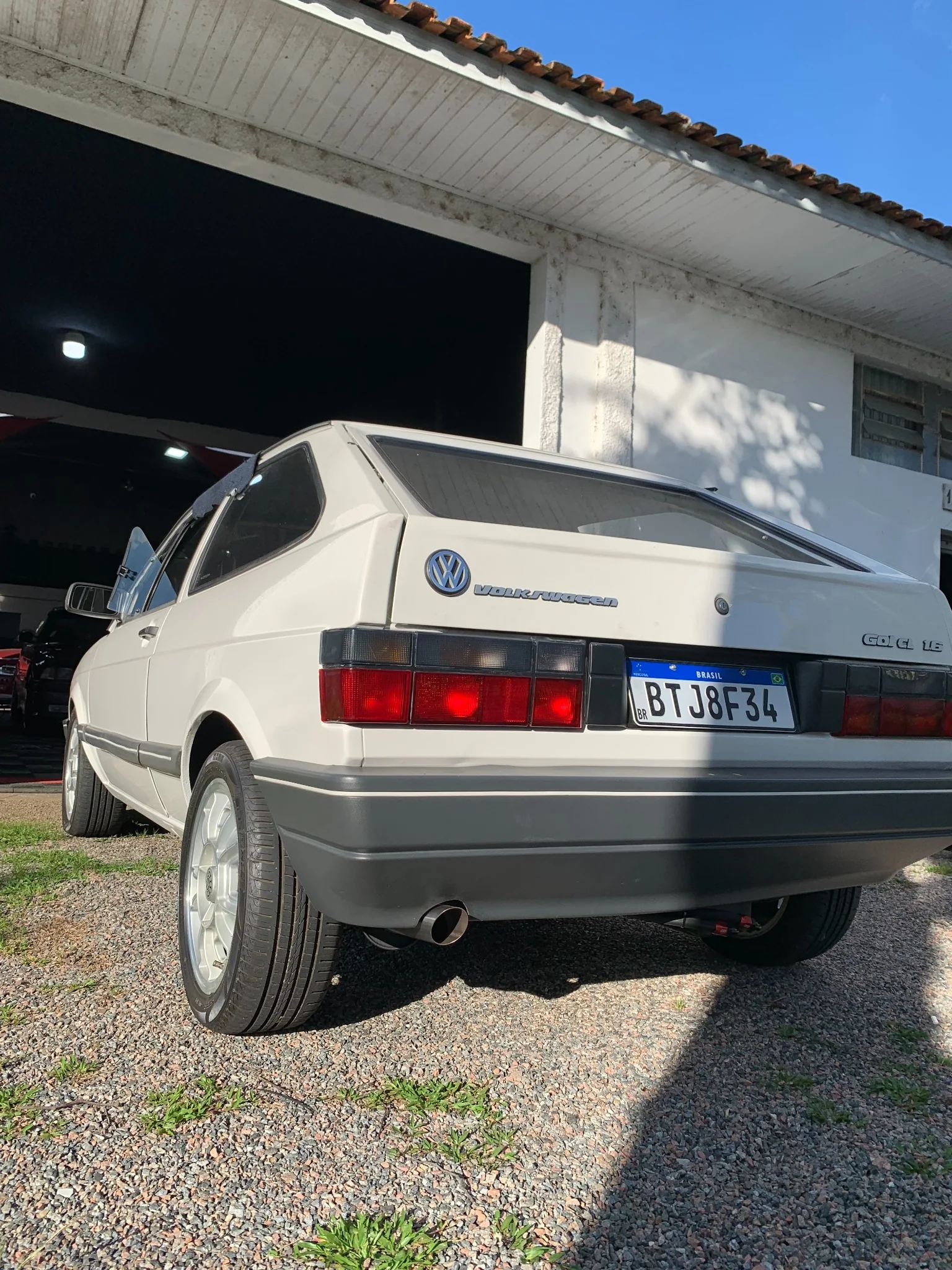 Gol Quadrado branco visto de trás, em frente à oficina
