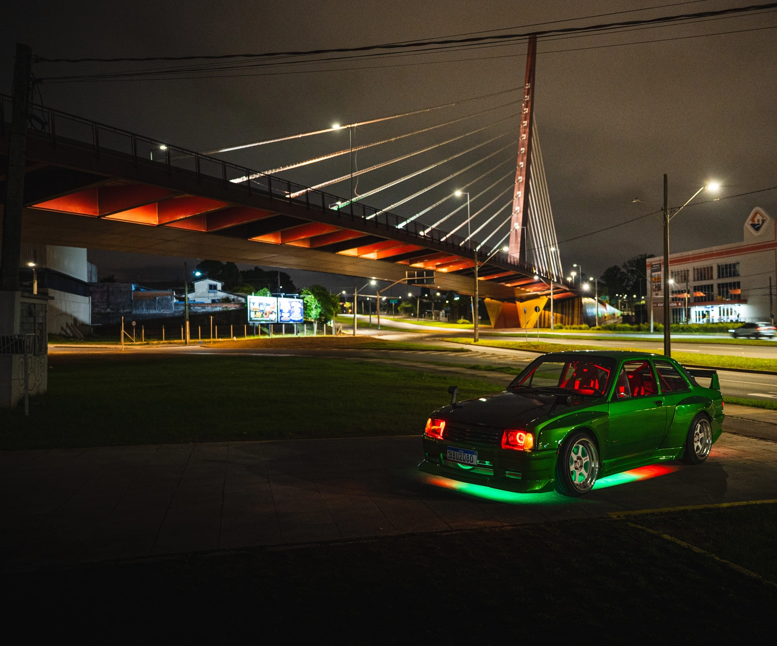 Chevette Grinch à noite, com iluminação verde e vermelha sob a carroceria