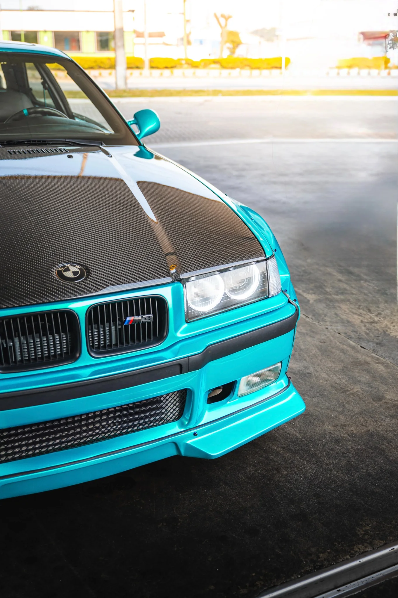 Detalhe da dianteira da BMW E36 Sullivan, com capô de fibra de carbono e pintura Sea Turquoise