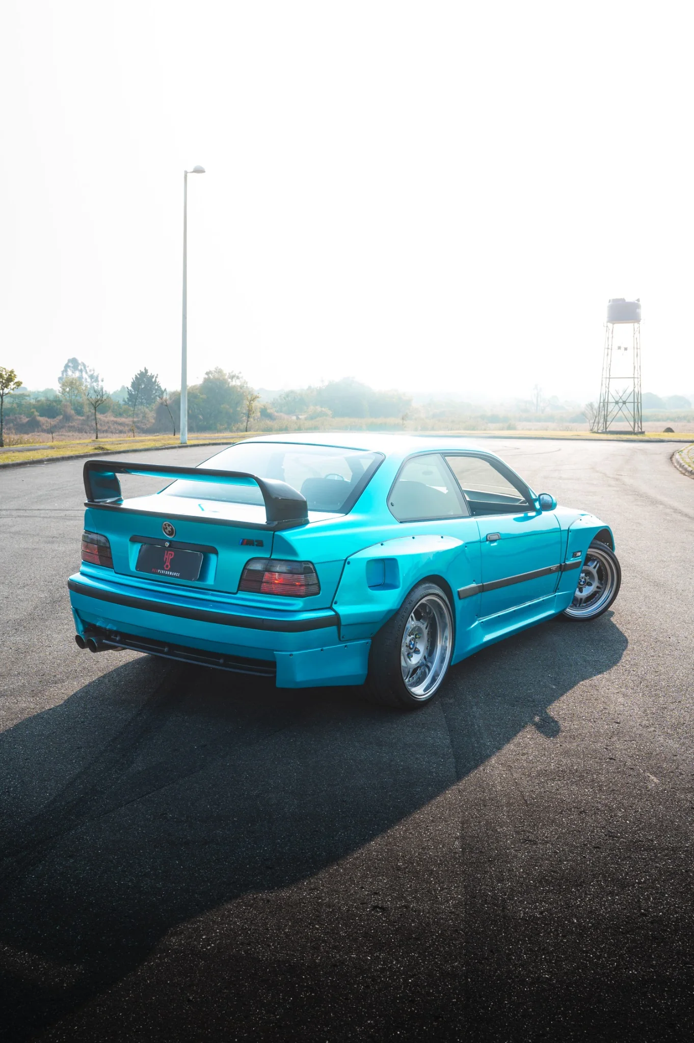 BMW E36 Sullivan vista de trás, com pintura Sea Turquoise, bodykit largo e aerofólio LTW